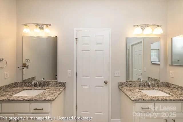 a bathroom with a granite countertop sink and a bathtub