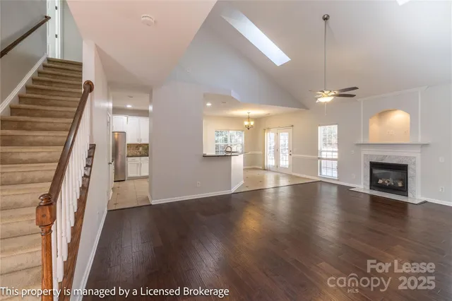 an empty room with wooden floor fireplace and window
