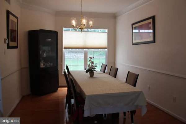 a view of a dining room with furniture wooden floor and chandelier