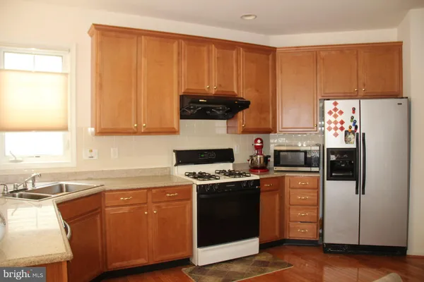 a kitchen with a stove a refrigerator and a sink