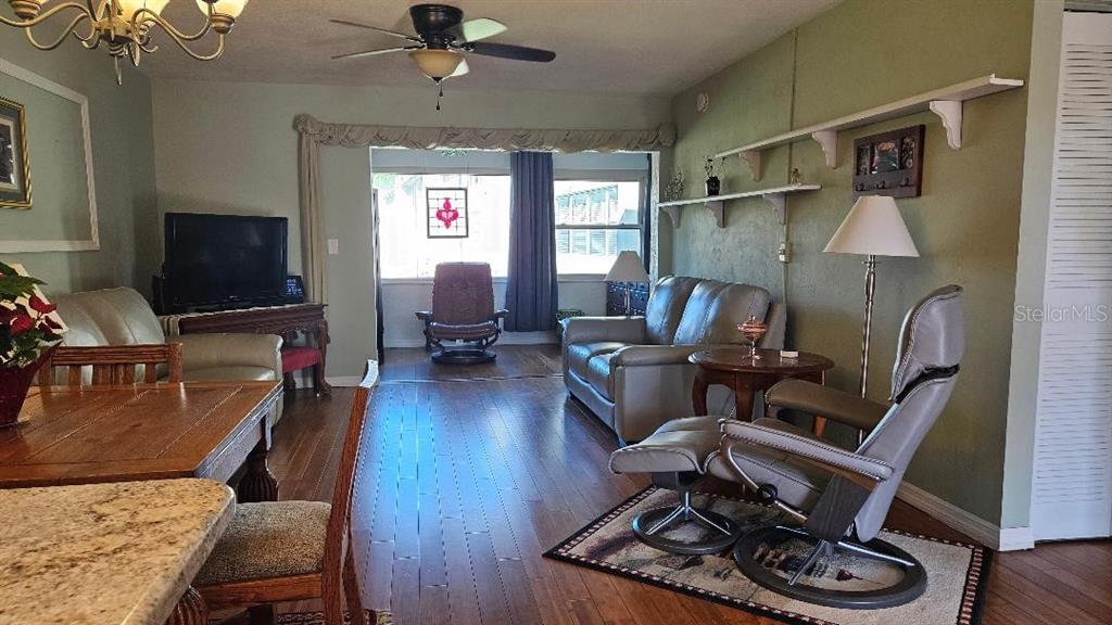 4600 98th Way North, Unit 210 St. Petersburg, FL 33708 - Photo 9 of 33 a living room with furniture or wooden floor and a flat screen tv