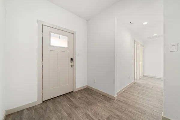 a view of an empty room with wooden floor