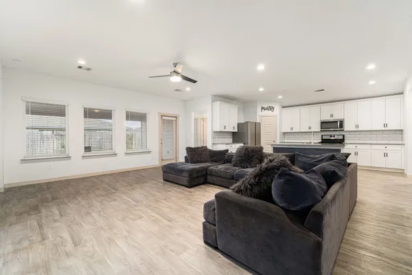 a living room with furniture and kitchen view