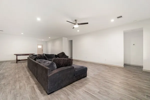 a living room with furniture and a ceiling fan