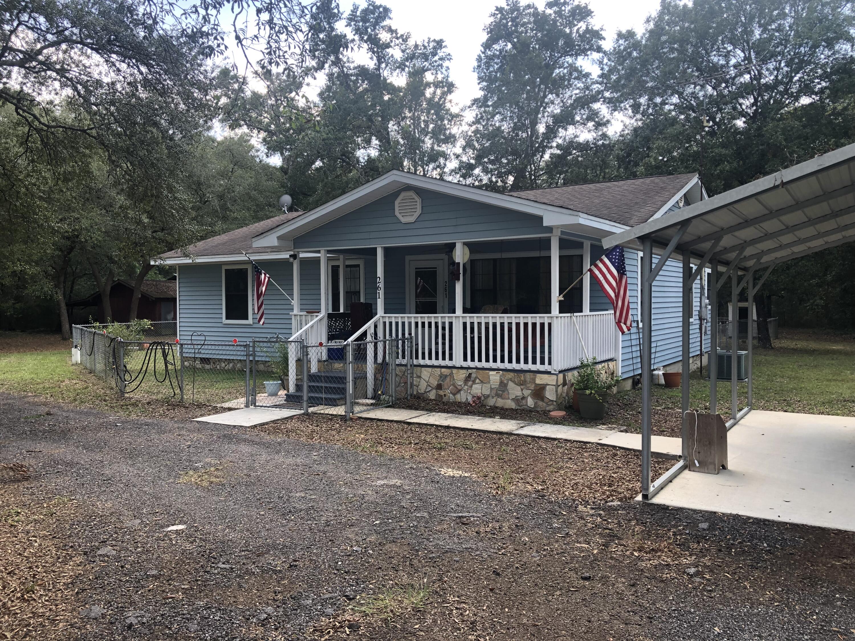 261 Roberts Road DeFuniak Springs, FL 32433 - Photo 2 of 18 a front view of a house with a yard table and chairs