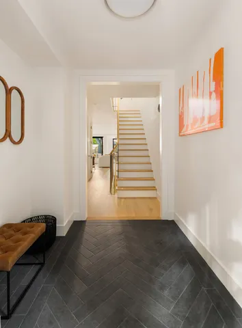 a view of a hallway with cabinet and wooden floor