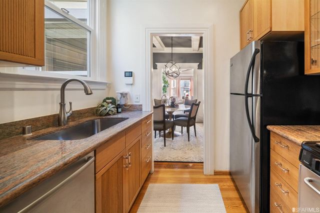a kitchen with stainless steel appliances granite countertop a refrigerator and a sink
