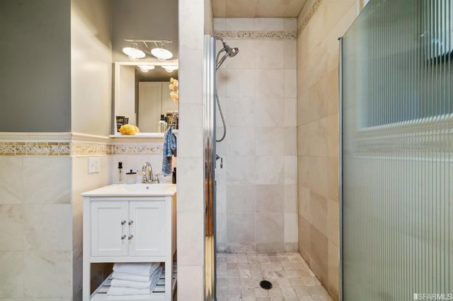 a bathroom with a shower a sink and a mirror