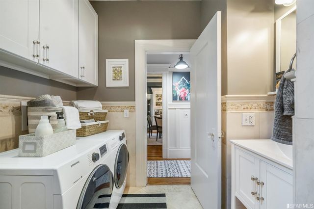 a view of washer and dryer with kitchen in the background