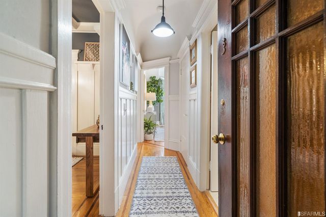a view of a hallway with wooden floor and staircase