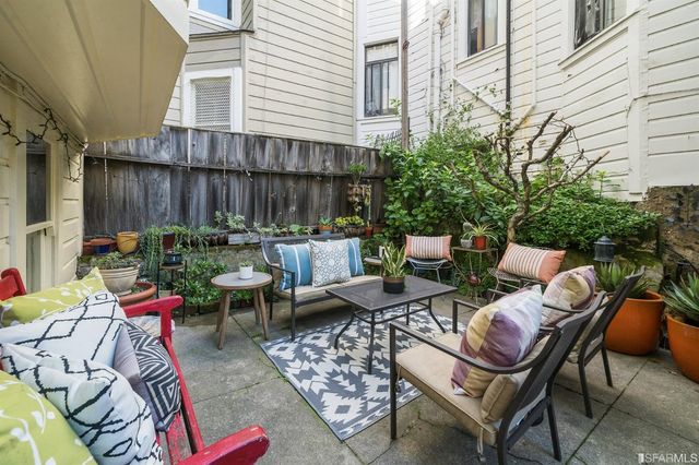 a view of a patio with a dining table and chairs with wooden fence