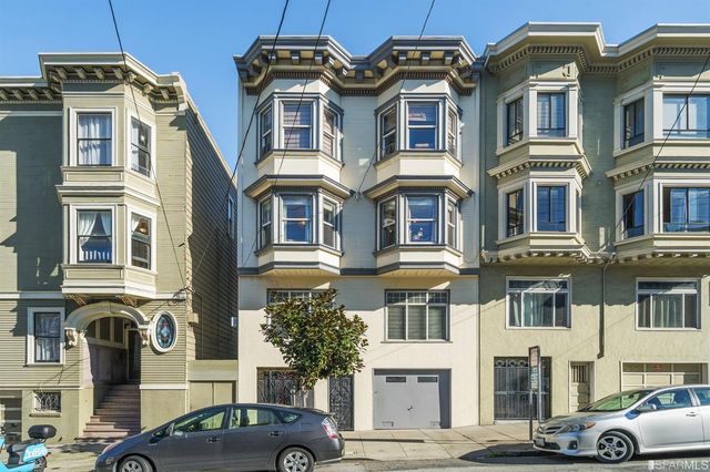 a front view of a residential apartment building with a yard
