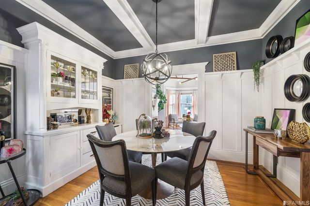 a view of a dining room with furniture a kitchen and chandelier