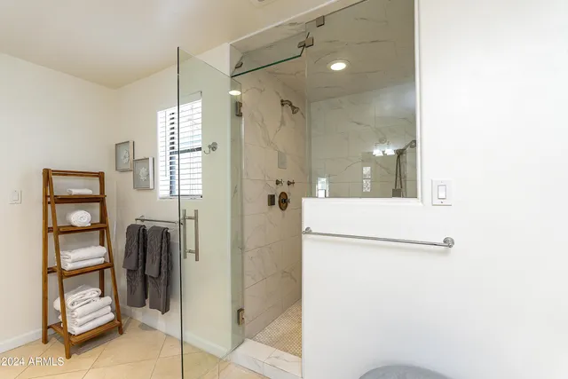 a bathroom with a granite countertop shower sink and mirror