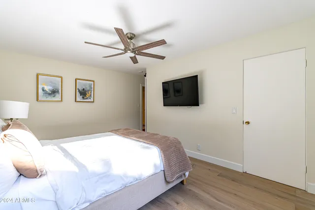 a spacious bedroom with a bed and a flat screen tv