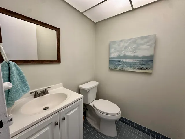 a bathroom with a toilet sink and mirror