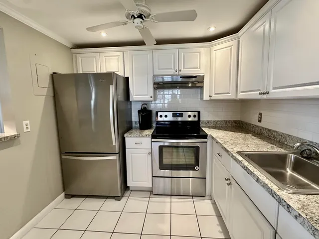 a kitchen with a refrigerator sink and cabinets
