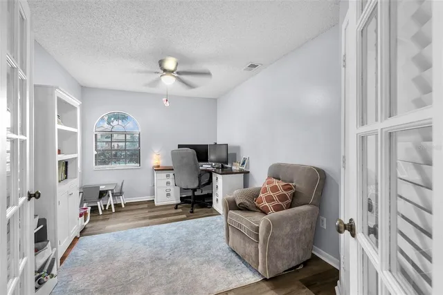 a living room with furniture a ceiling fan and a window