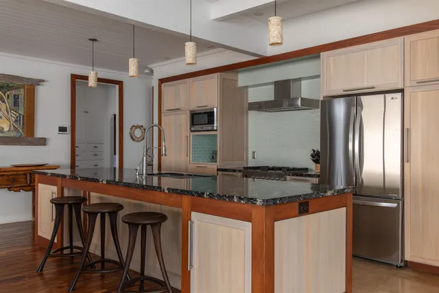 a kitchen with stainless steel appliances granite countertop a sink and a refrigerator