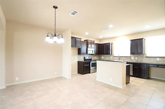 a kitchen with granite countertop a stove and a sink