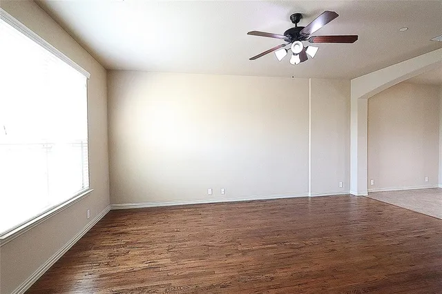 a view of a kitchen with a dishwasher a kitchen island hardwood floor and a ceiling fan