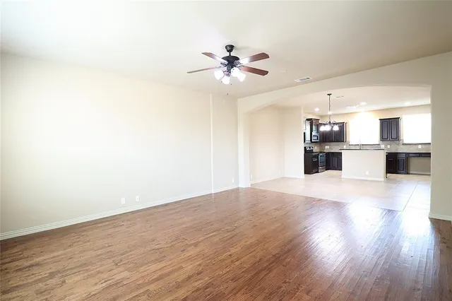 a view of a kitchen with wooden floor and a ceiling fan