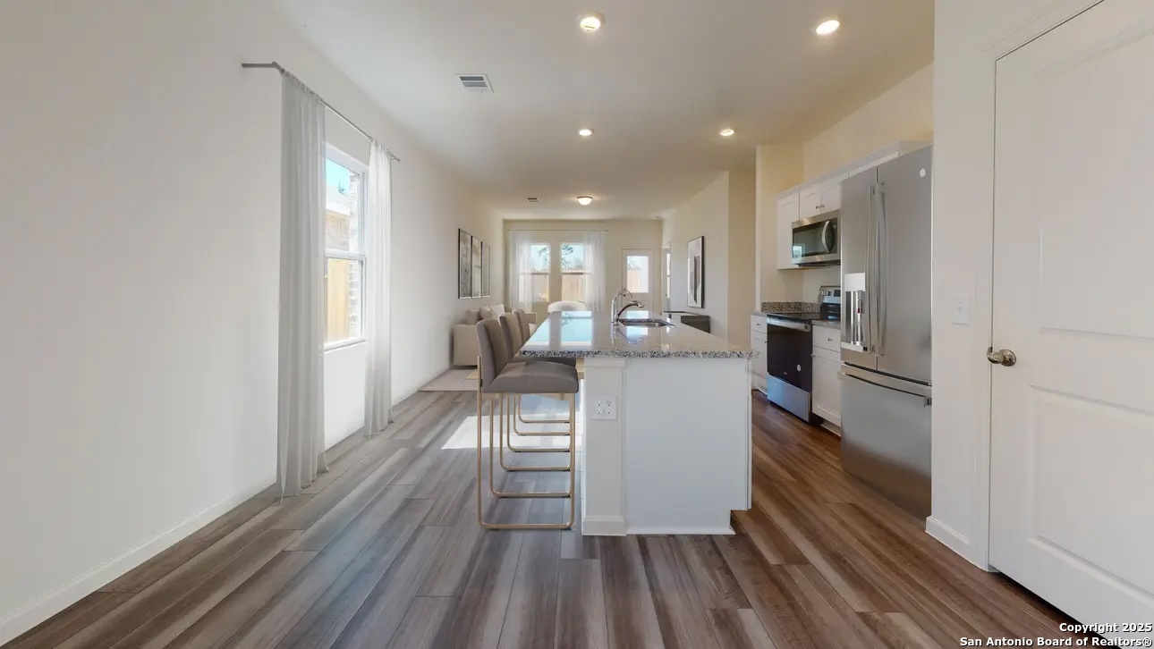 10506 Lesser Snow Adkins, TX 78101 - Photo 3 of 9 a kitchen with white cabinets and stainless steel appliances