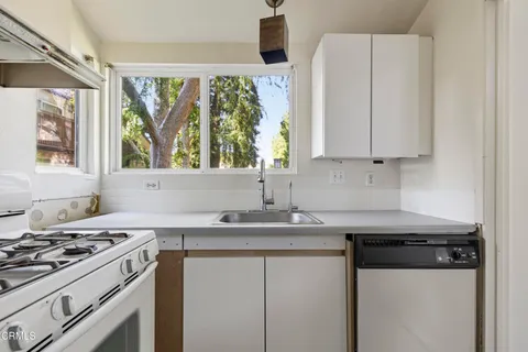 a kitchen with stainless steel appliances a sink stove and window