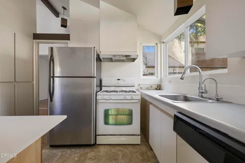 a kitchen with a stove a refrigerator and a sink
