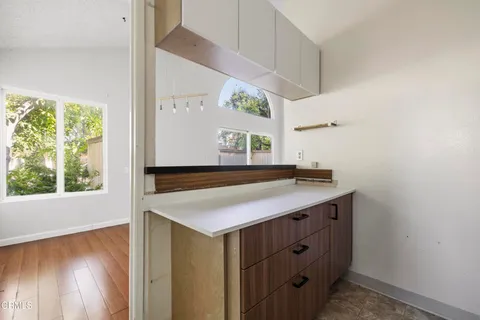 a kitchen with a sink a large window and wooden floor