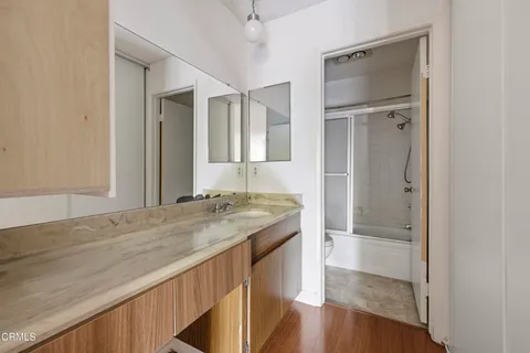 a bathroom with a granite countertop sink mirror and shower