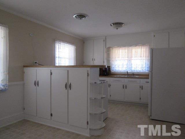 2695 Johnston County Road Angier, NC 27501 - Photo 8 of 25 a kitchen with white cabinets and window