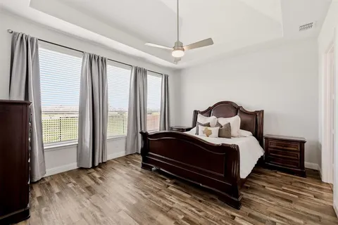 a bedroom with a bed and large windows