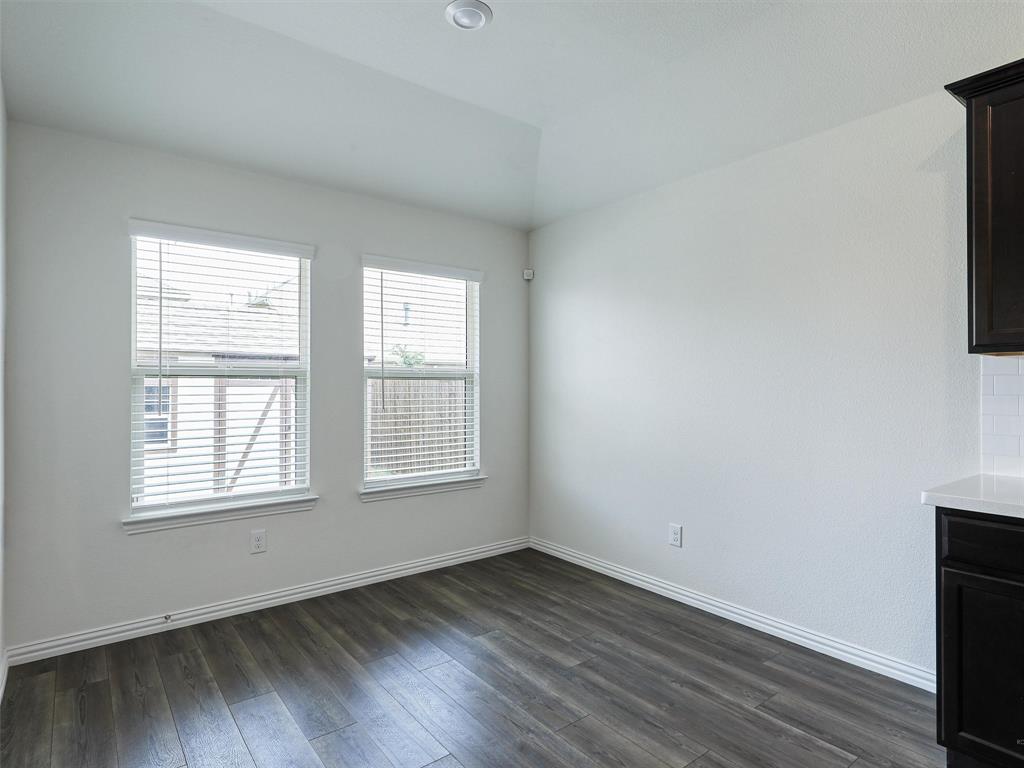 910 Torrey Avenue Princeton, TX 75407 - Photo 14 of 39 an empty room with wooden floor and windows