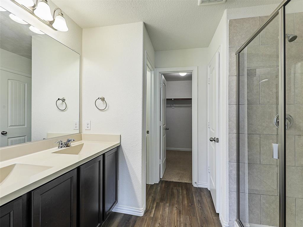 910 Torrey Avenue Princeton, TX 75407 - Photo 21 of 39 a bathroom with a double vanity sink a toilet and shower