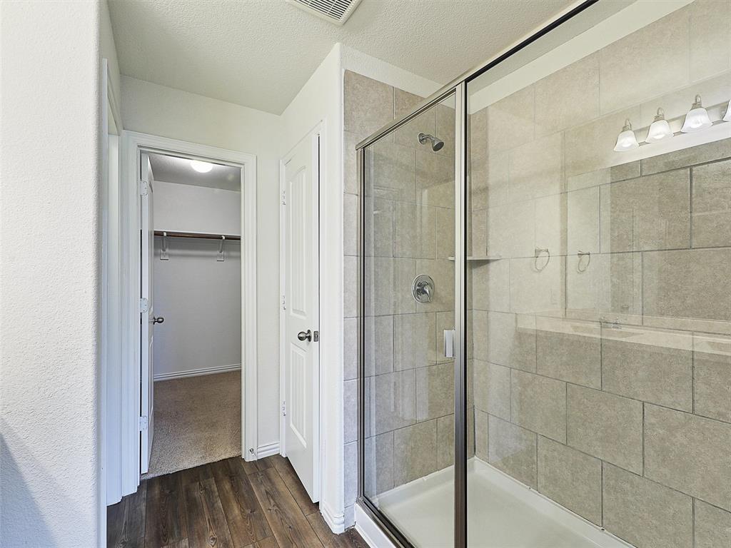 910 Torrey Avenue Princeton, TX 75407 - Photo 22 of 39 a bathroom with a glass shower door