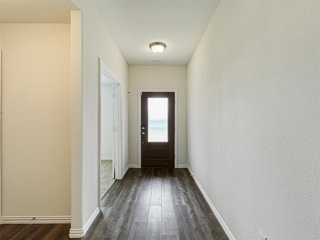 910 Torrey Avenue Princeton, TX 75407 - Photo 3 of 39 a view of a hallway with wooden floor and a bathroom