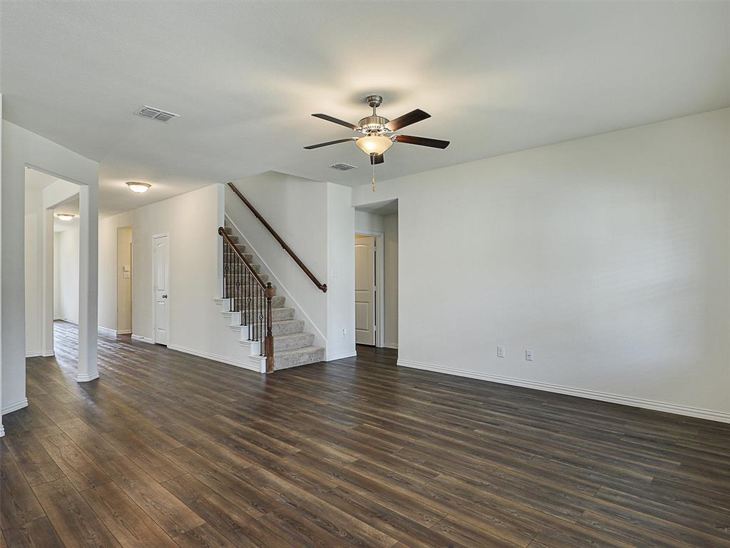 910 Torrey Avenue Princeton, TX 75407 - Photo 9 of 39 a view of an empty room with wooden floor and a ceiling fan