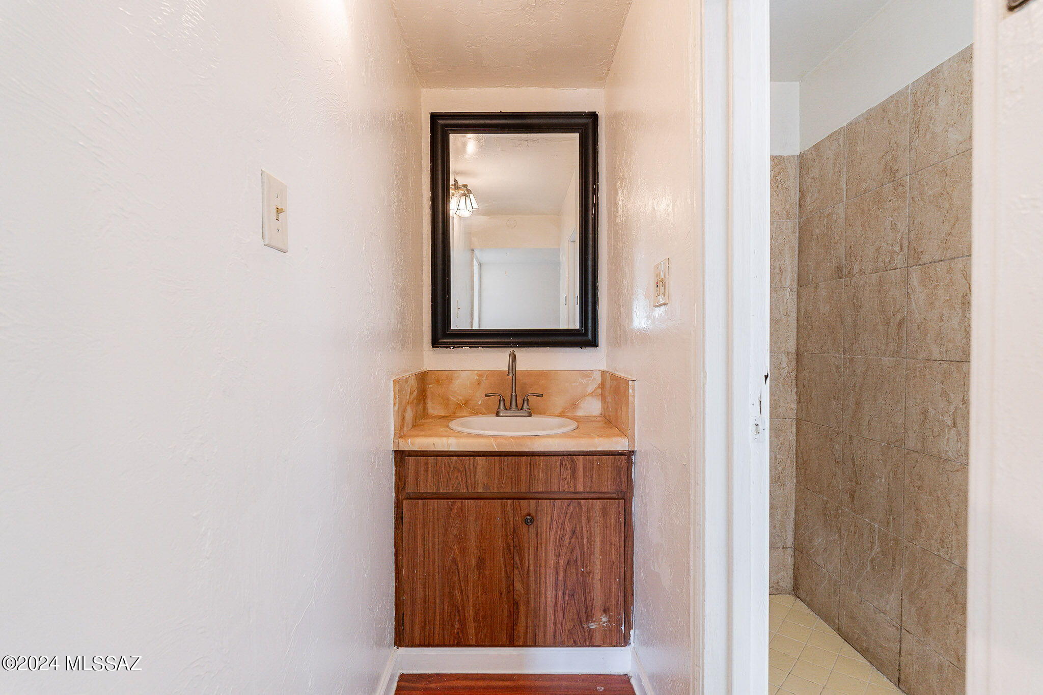 608 East Roger Road Tucson, AZ 85705 - Photo 10 of 13 a bathroom with a sink a mirror and vanity