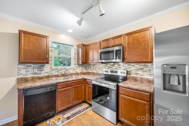 a kitchen with stainless steel appliances granite countertop stove top oven microwave and refrigerator