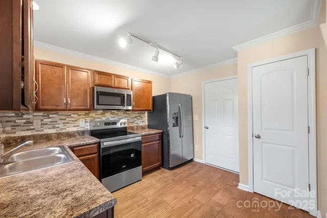 a kitchen with stainless steel appliances granite countertop a refrigerator stove and sink