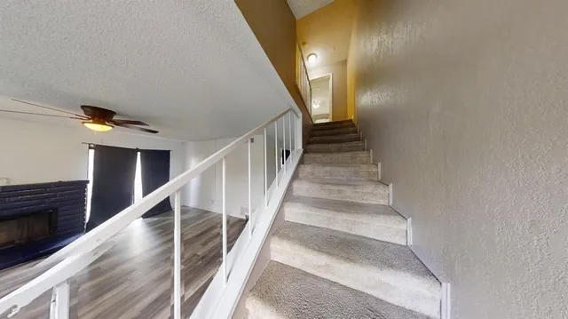 a kitchen with stainless steel appliances granite countertop a refrigerator a sink and a stove with wooden floor