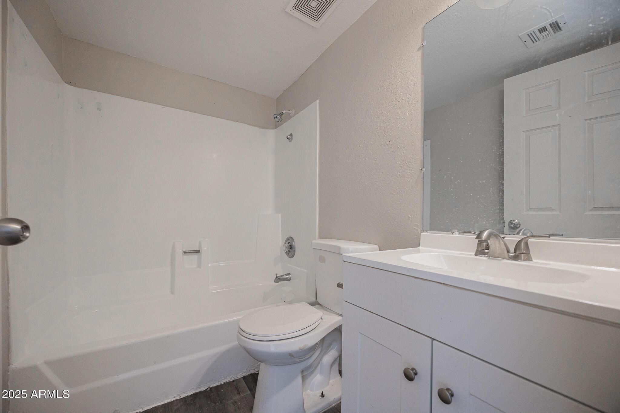 1703 West Mountain View Road, Unit 1 Phoenix, AZ 85021 - Photo 11 of 13 a bathroom with a toilet a sink a mirror and a shower