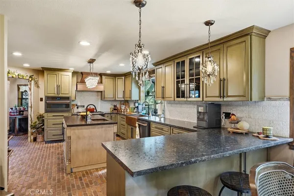 a kitchen with granite countertop a sink a counter top space appliances and cabinets