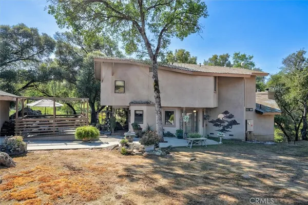 a view of a house with backyard and trees