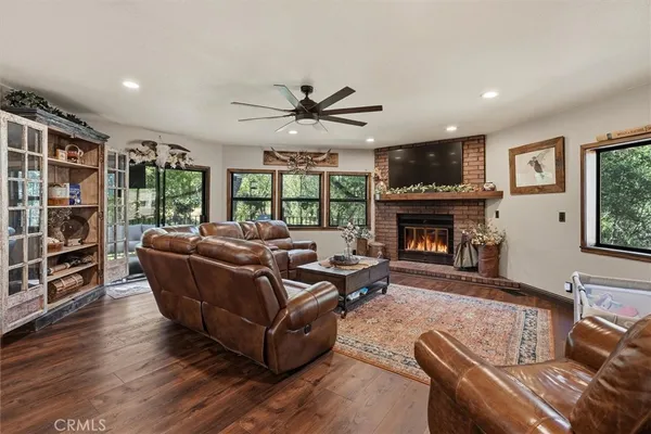 a living room with furniture a ceiling fan and a large window