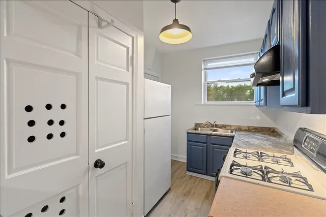 a kitchen with stainless steel appliances granite countertop a stove a sink and a refrigerator