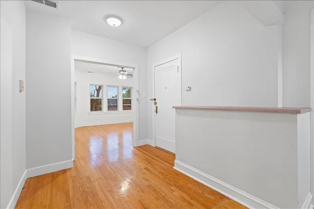 a view of empty room with wooden floor
