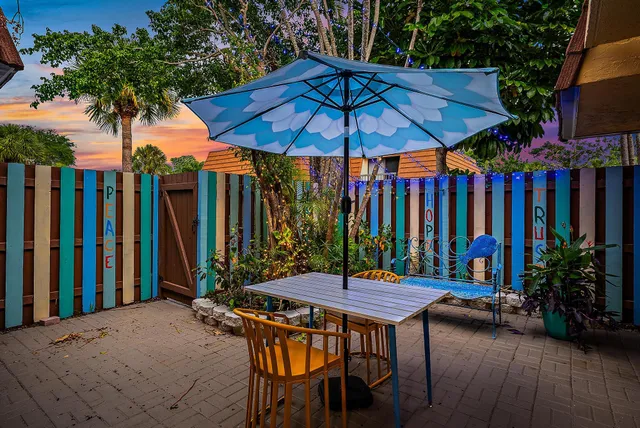 a patio with a table and chairs under an umbrella