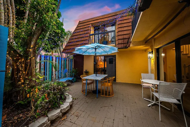 a view of a patio with a table and chairs under an umbrella